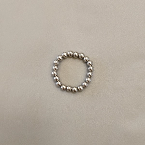 Macro shot of silver beaded elastic ring with polished stainless steel metal spheres