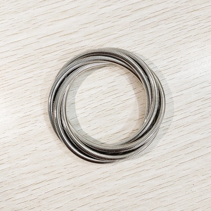 Detalle de brazaletes de espiral plateados de varias capas con un acabado metálico