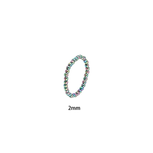 Primer plano de cuentas de acero de titanio arcoíris de 2mm en un anillo elástico