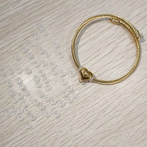 Bracciale rigido dorato a spirale con ciondolo a cuore e anelli distanziatori in silicone