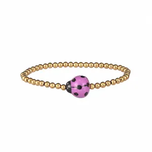 Detail of stainless steel bead bracelet with purple ceramic ladybug and PVD gold plating