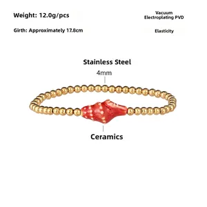 Detail of waterproof stainless steel bead bracelet with a red ceramic conch shell charm