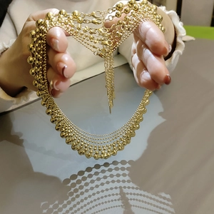 Detail of layered gold beaded necklace with adjustable lobster clasp and polished finish