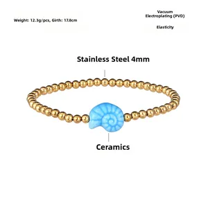 Close-up of golden steel bead bracelet with a light blue ceramic shell pendant