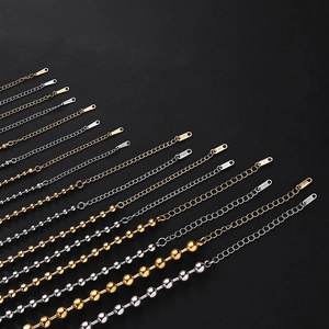 Polished stainless steel ball and link chains in gold and silver finishes on black background