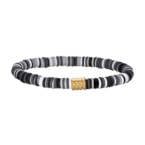 Close-up of bohemian clay bead bracelet in black and white with golden cylinder metal charm