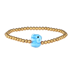 Detail of golden beaded bracelet with a light blue ceramic elephant pendant on white back