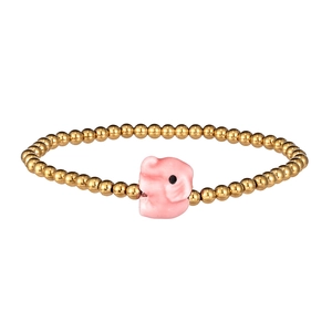 Macro view of gold-plated beads and a pink ceramic elephant charm on the bracelet