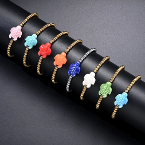 Detail of colorful sea turtle charms and metallic beads on elastic bracelet set