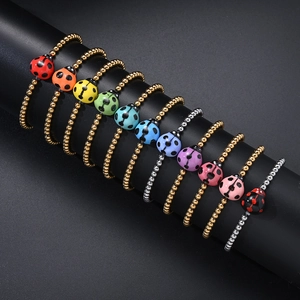 Detailed view of colorful enamel ladybug pendants on stainless steel beaded bracelets