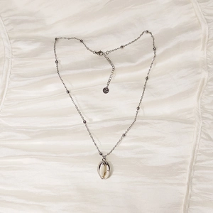 Silver stainless steel bead chain necklace featuring a detailed shell pendant on satin silk