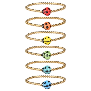 Detailed view of six gold-beaded bracelets with colorful ceramic ladybug charms