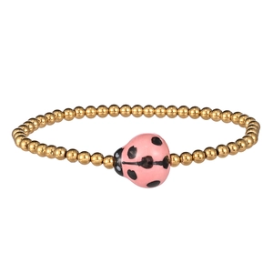 Close-up of golden beaded bracelet featuring a pink ladybug charm with black spots
