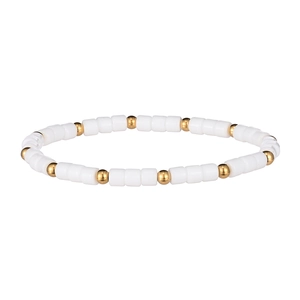 Dettaglio di perle cilindriche bianche e sfere metalliche dorate sul bracciale