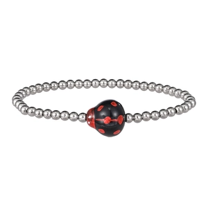 Detail of silver beaded bracelet featuring a red and black ladybug ceramic charm