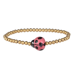 Macro view of gold beaded bracelet featuring a cute pink ladybug pendant with black spots