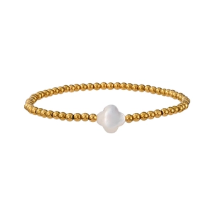 Macro detail of gold beaded bracelet featuring a white mother-of-pearl clover charm