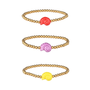 Close-up of three gold-beaded bracelets with colorful spiral shell charms in red and yellow