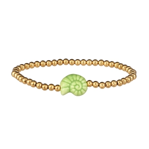 Macro detail of gold beaded bracelet with a light green ceramic nautilus shell charm