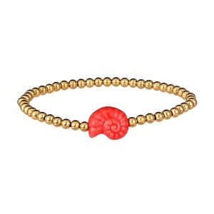 Close-up of ocean-themed beaded bracelet with gold steel beads and red ceramic nautilus