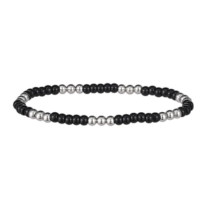 Détail du bracelet perlé avec des perles noires lisses et des perles en métal argenté sur blanc