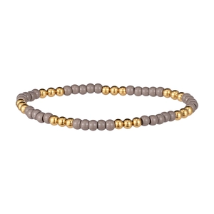 Vue détaillée des perles polies grises et dorées sur un bracelet élastique minimaliste