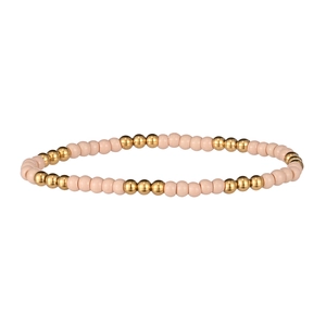 Détail d'un bracelet perlé avec alternance de perles en résine nude et de billes dorées