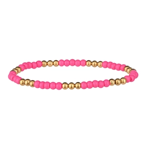 Vue détaillée des perles roses mates et des perles dorées en acier inoxydable sur le bracelet