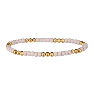 Détail d'un bracelet élastique avec perles crème et perles métalliques dorées