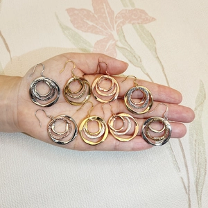 Macro detail of 8 pairs set with triple layered circular hoop earrings in mixed metal tones