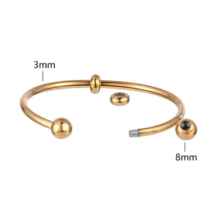 Detail showing 8mm metal bead and 3mm flexible steel pipe on gold open bracelet