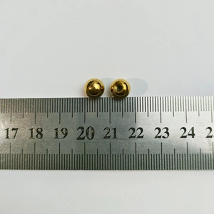 Detail view of 8mm golden stainless steel beads with a ruler for size reference