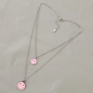 Dettaglio della collana a doppio strato in acciaio inox con ciondoli smiley in smalto rosa