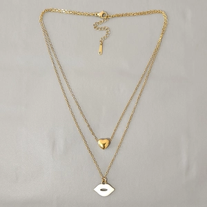 Detail of double-layer gold chain with white enamel lip pendant and heart charm