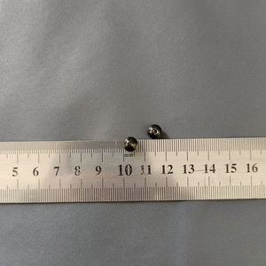 Detailed macro view of two 5mm polished black beads against a metric measuring ruler