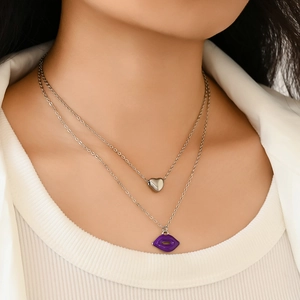 Double-layered silver titanium steel necklace with purple lip and heart pendants on a model