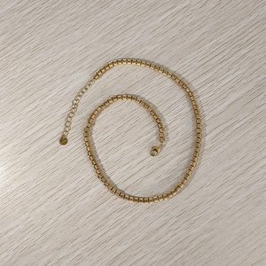 Dettaglio della collana con perle in acciaio placcato oro 18K con texture a spirale e gancio