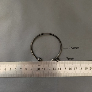 Macro detail of 2.5mm steel piercing jewelry with a 7mm screw-on ball and ruler measurement