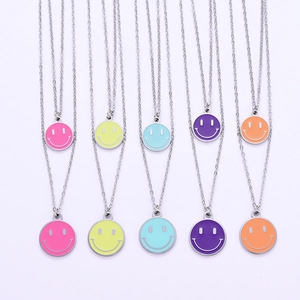 Dettaglio di cinque ciondoli smiley colorati su catene argentate a doppio strato