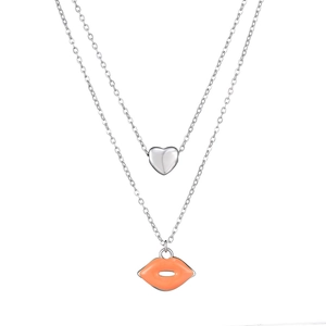 Detailed view of double-layer necklace with silver heart and orange enamel lip pendants