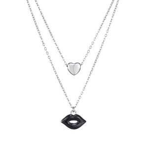 Macro detail of silver double-layered necklace featuring heart and black lip pendants