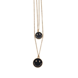 Dettaglio della collana a doppio strato dorata con pendenti smiley in smalto nero
