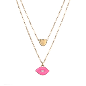 Close-up of double-layer gold chain with pink enamel lips and mini heart pendant