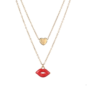 Close-up of double-layer gold necklace with heart pendant and red lip charm
