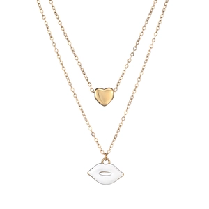Detail of layered gold necklace featuring a 3D heart and white enamel lip pendant