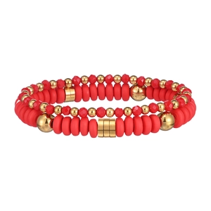 Dettaglio di due braccialetti di perline rosse e oro con perline Heishi e finiture in oro