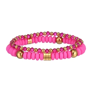 Dettaglio di perline Heishi fucsia e distanziatori dorati nel set di braccialetti doppi