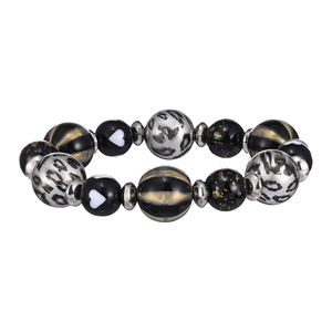 Dettaglio di perline in resina con motivo leopardato e cuore su un bracciale multi-elemento