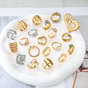 Dettaglio di anelli con perle oro e argento e gemme su vassoio bianco elegante