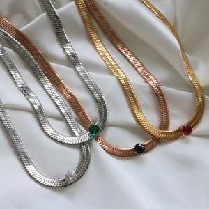 Detail view of 18K gold plated herringbone chains with multicolored zircon gemstone settings